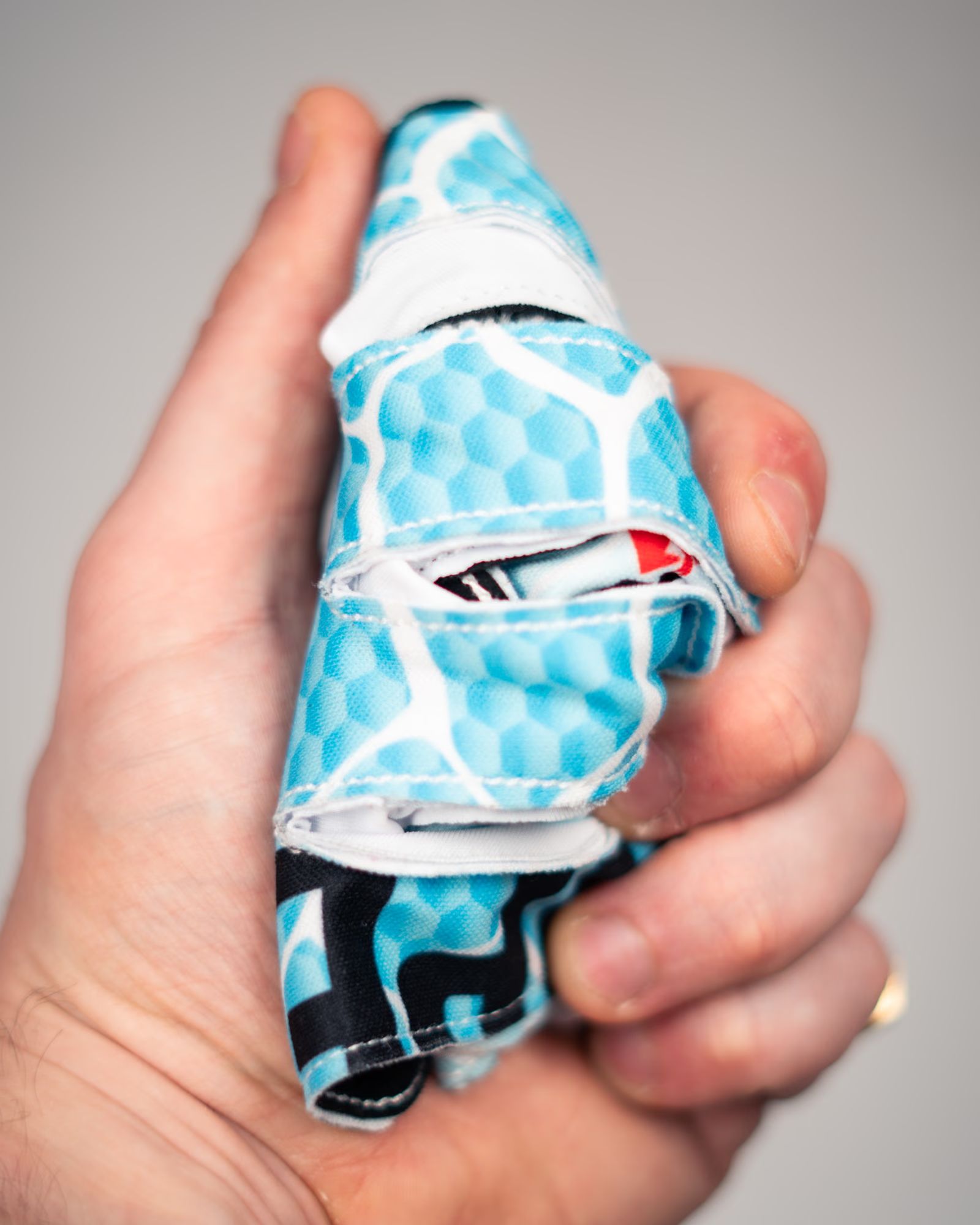 A V2 Ice Serpent glove squeezed in one hand, showing how soft the material is.